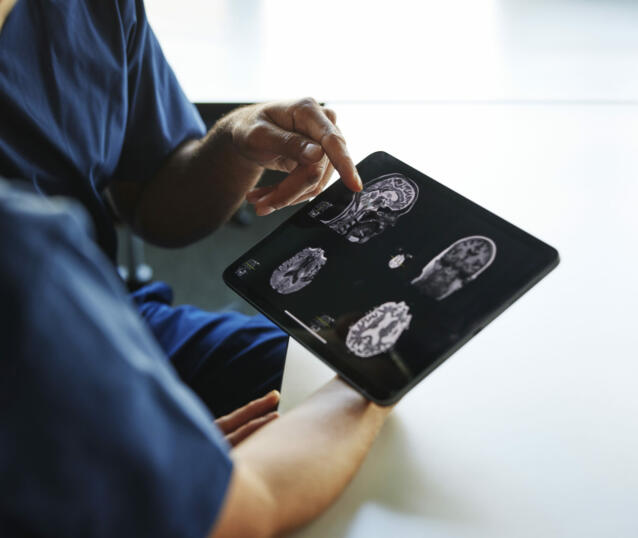Two doctors looking at x-ray images on digital tablet